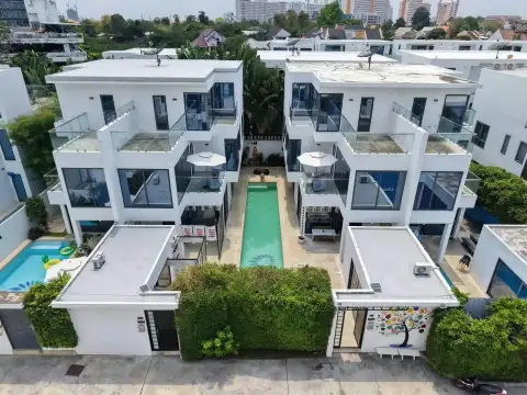 4 Bedroom House for Sale at Palm Spring villa Pattaya aerial view of villa complex with lap pool and city skyline