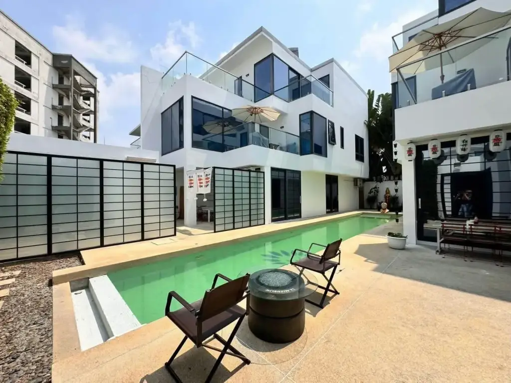 4 Bedroom House for Sale at Palm Spring villa Pattaya open-plan living room with gray sofa and Japanese wave wall art