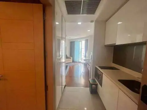 1 Bedroom Condo for Sale at Palm Wongamat narrow kitchenette with white cabinets and hallway view