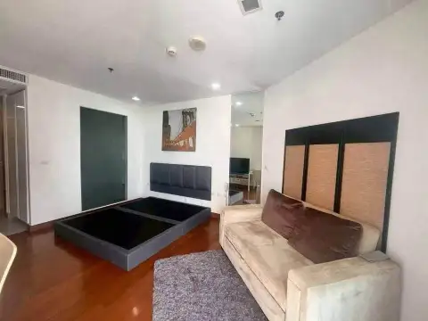 1 Bedroom Condo for Sale at Palm Wongamat living area with sofa, bed frame and wall art