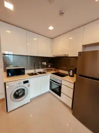 2 Bedroom Condo for Sale at Palm Wongamat fitted kitchen with white cabinets and stainless appliances