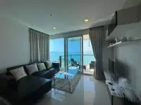 2 Bedroom Condo for Sale at Palm Wongamat living room with sea view balcony and leather sofa