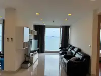 3 Bedroom Condo for Sale at Palm Wongamat living room with black leather sofa and ocean view windows