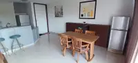 2 Bedroom Condo for Sale at Panchalae Boutique Residence dining area with wooden table, chairs, and fridge