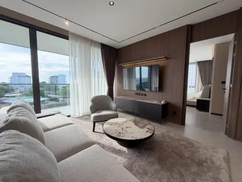 3 Bedroom Condo for Rent at Panora Estuaria lounge area with TV wall unit and city view through sheer curtains