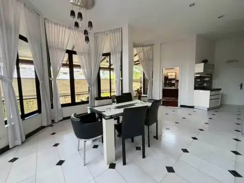 5 Bedroom House for Rent at Paradise Villa 1 & 2 open dining area with black chairs and view into kitchen