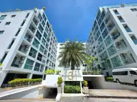 1 Bedroom Condo for Rent at Park Royal 3 building entrance with signage, palm tree and parking area