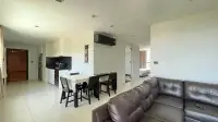 2 Bedroom Condo for Rent at Park Royal 3 open-plan living area with kitchen, dining table, and leather sofa