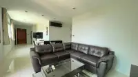 2 Bedroom Condo for Rent at Park Royal 3 living room with brown leather sectional sofa and glass coffee table