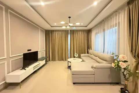 3 Bedroom House for Rent at Patta Define bright living room with beige sofa, TV console, and gold curtains