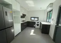 3 Bedroom House for Sale at Patta Define modern kitchen with dark cabinets, stainless fridge, and washer