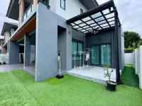 4 Bedroom House for Sale at Patta Define backyard patio with artificial turf lawn and covered seating area