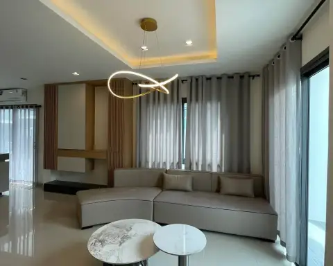 4 Bedroom House for Rent at Patta Element living room with curved sofa and sheer curtains