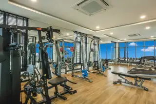 Patta Prime well-equipped fitness center with various weight machines, benches, and mirrored walls.