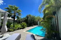 3 Bedroom House for Sale in Huai Yai poolside patio view surrounded by lush palm garden landscaping