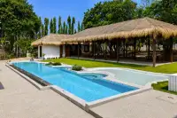 4 Bedroom House for Rent in Huai Yai daytime view of pool, thatched pavilion, and garden landscaping