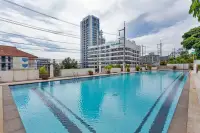 8 Bedroom House for Sale in Pratumnak Hill wide lap pool with lane markings and high-rise Tara Court building in background