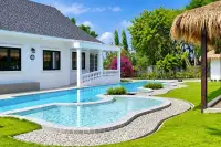 4 Bedroom House for Rent in Huai Yai white villa with curved swimming pool and lush green lawn