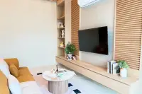3 Bedroom House for Rent at Narita Villa cozy living room with wall-mounted TV and wooden shelving