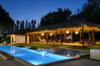 4 Bedroom House for Rent in Huai Yai nighttime pool and thatched pavilion with warm lighting