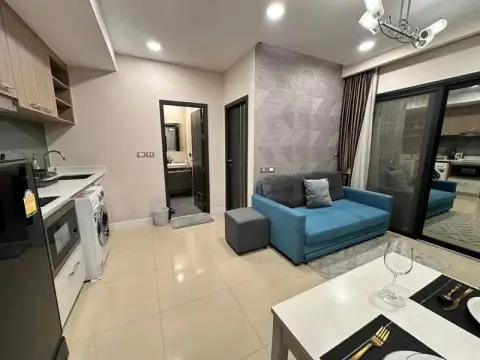 1 Bedroom Condo for Sale at Dusit Grand Condo View open living area with kitchenette, sofa and balcony door