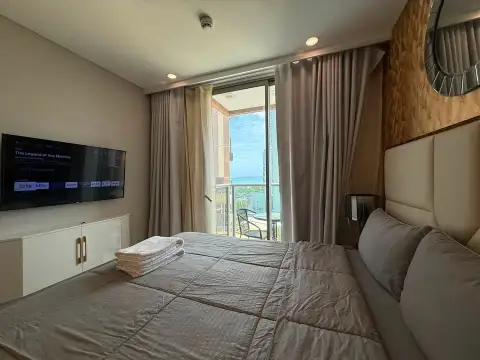 1 Bedroom Condo for Sale at Copacabana Beach Jomtien bedroom with wall-mounted TV and balcony sea view