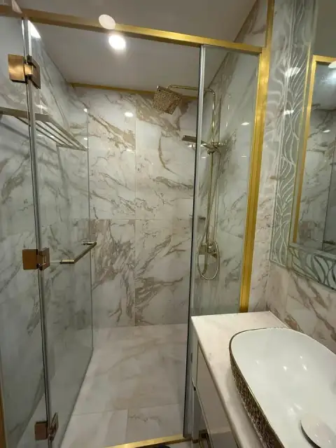 1 Bedroom Condo for Sale at Copacabana Beach Jomtien marble bathroom with glass shower and gold fixtures