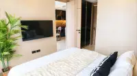 1 Bedroom Condo for Sale at Riviera Ocean Drive bedroom with wall-mounted TV and view into kitchen and dining area