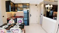 1 Bedroom Condo for Sale at Riviera Ocean Drive modern kitchen with marble countertops and dark cabinetry near entrance hallway