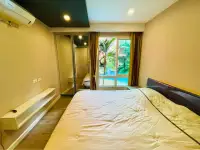 1 Bedroom Condo for Sale at Seven Seas Condo Resort bed facing window with palm trees and pool view