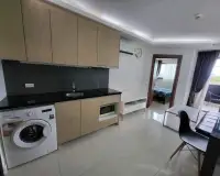 1 Bedroom Condo for Sale at Laguna Beach Resort 3 (The Maldives) kitchenette with washing machine, sink and view into bedroom