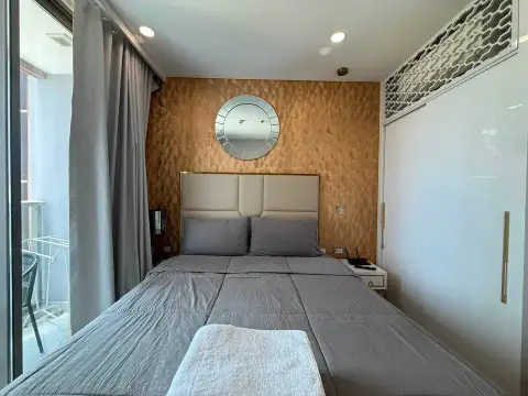 1 Bedroom Condo for Sale at Copacabana Beach Jomtien bedroom view with balcony curtains and bedside table