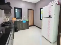 2 Bedroom House for Sale at Thanyawan Home kitchen with black countertops, gas stove and white refrigerator