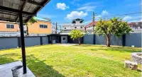 2 Bedroom House for Sale at Thanyawan Home spacious grassy backyard with trees and perimeter wall