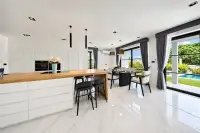 5 Bedroom House for Sale at Highgrove Villas open-plan kitchen with white cabinetry and wood island