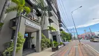 1 Bedroom Condo for Sale exterior entrance of Nirvana Place building with palm trees in Pattaya