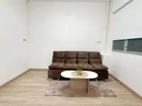 2 Bedroom Condo for Sale at Eua Arthorn Naklua living room with brown sofa, round coffee table, and wood flooring