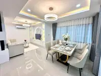 3 Bedroom House for Sale in Na Kluea dining area with gold-accented table and crystal ring chandelier