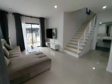 4 Bedroom House for Rent in Central Pattaya living room with sofa, TV, and wooden staircase
