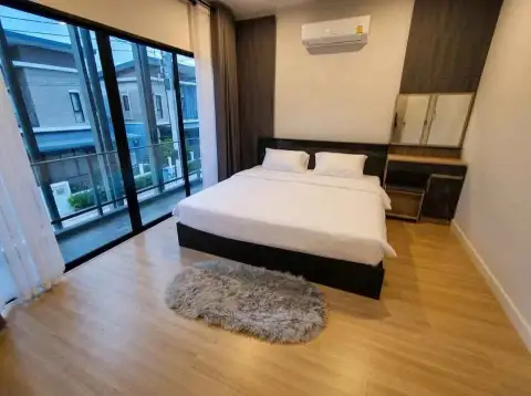 4 Bedroom House for Rent in Central Pattaya bedroom with wooden flooring and balcony access