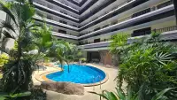 1 Bedroom Condo for Sale curved pool with rock features overlooked by building balconies