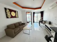 1 Bedroom Condo for Sale at C View Residence 2 living room with brown sofa, dining table and balcony access