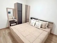 2 Bedroom Condo for Sale at Eua Arthorn Naklua master bedroom with queen bed, wardrobe, and vanity mirror