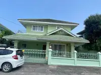 3 Bedroom House for Sale in Pattaya - green two-story exterior with tiled roof and gated driveway