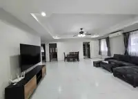 3 Bedroom House for Rent at Pattaya Lagoon Village spacious living room with dark sectional sofa and dining area