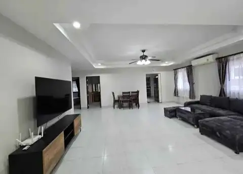 3 Bedroom House for Rent at Pattaya Lagoon Village spacious living room with dark sectional sofa and dining area