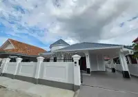 3 Bedroom House for Rent at Pattaya Lagoon Village street view of house behind white perimeter wall and gate