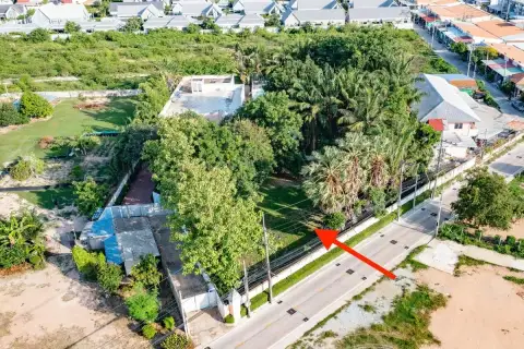 Land for Sale in East Pattaya aerial shot with arrow pointing to roadside plot surrounded by dense trees