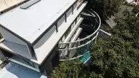 6 Bedroom House for Sale in Pratumnak Hill aerial view of curved balcony and rooftop pool surrounded by trees