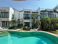 2 Bedroom Townhouse for Sale in Pattaya with curved swimming pool and sun loungers facing the building